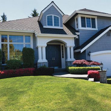 a large house with a lush green lawn in front of it