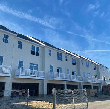 a row of apartment buildings under construction with balconies and garages .