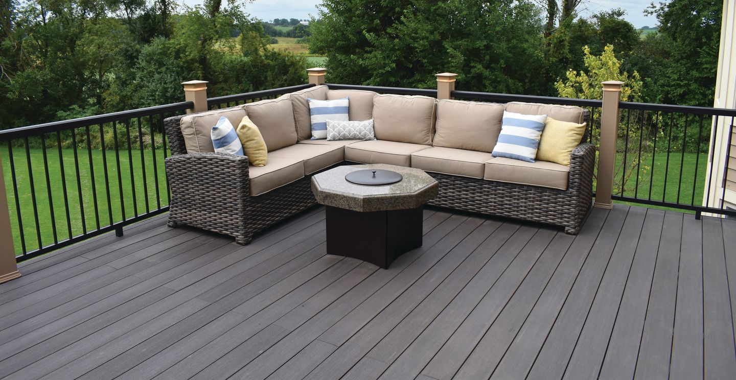 there is a couch and a table on the deck .