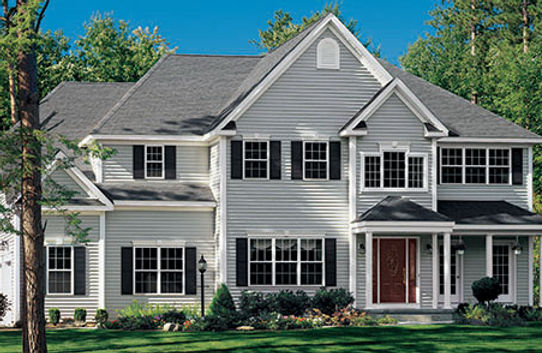 a large white house with black shutters and a red door
