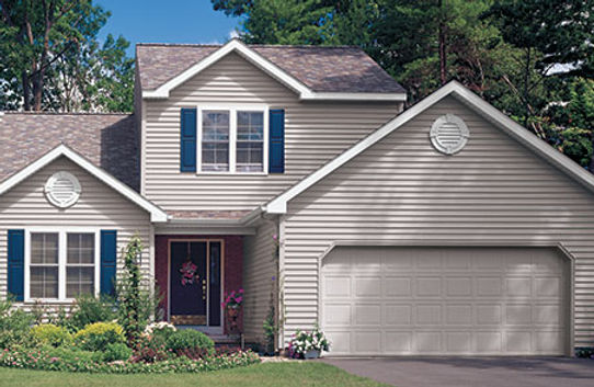 a large house with two garage doors and blue shutters .