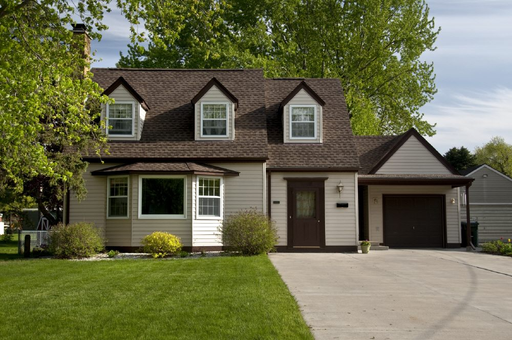 a house with a brown roof and white siding