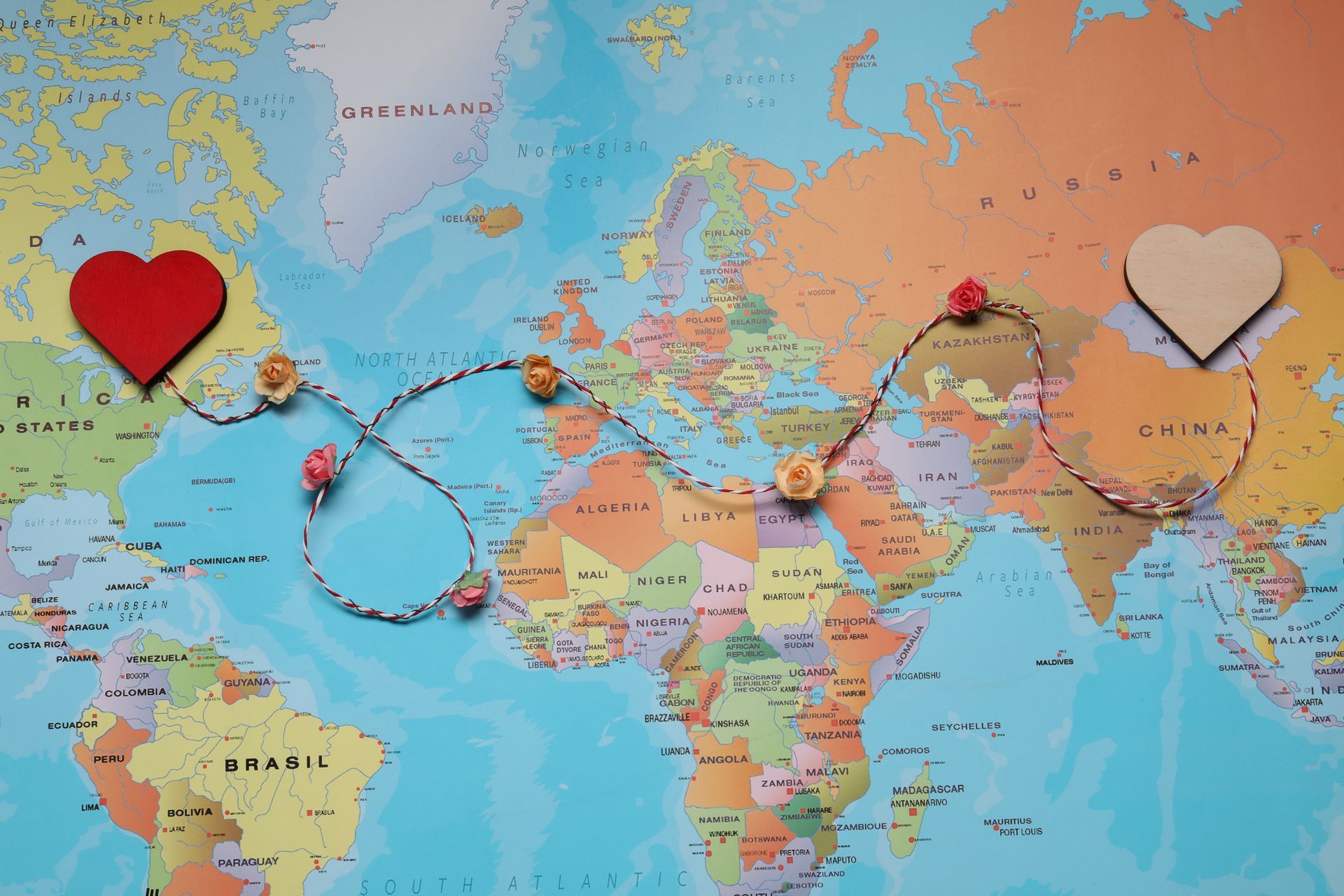 World map with red and white heart pins connected by a looping dashed route line