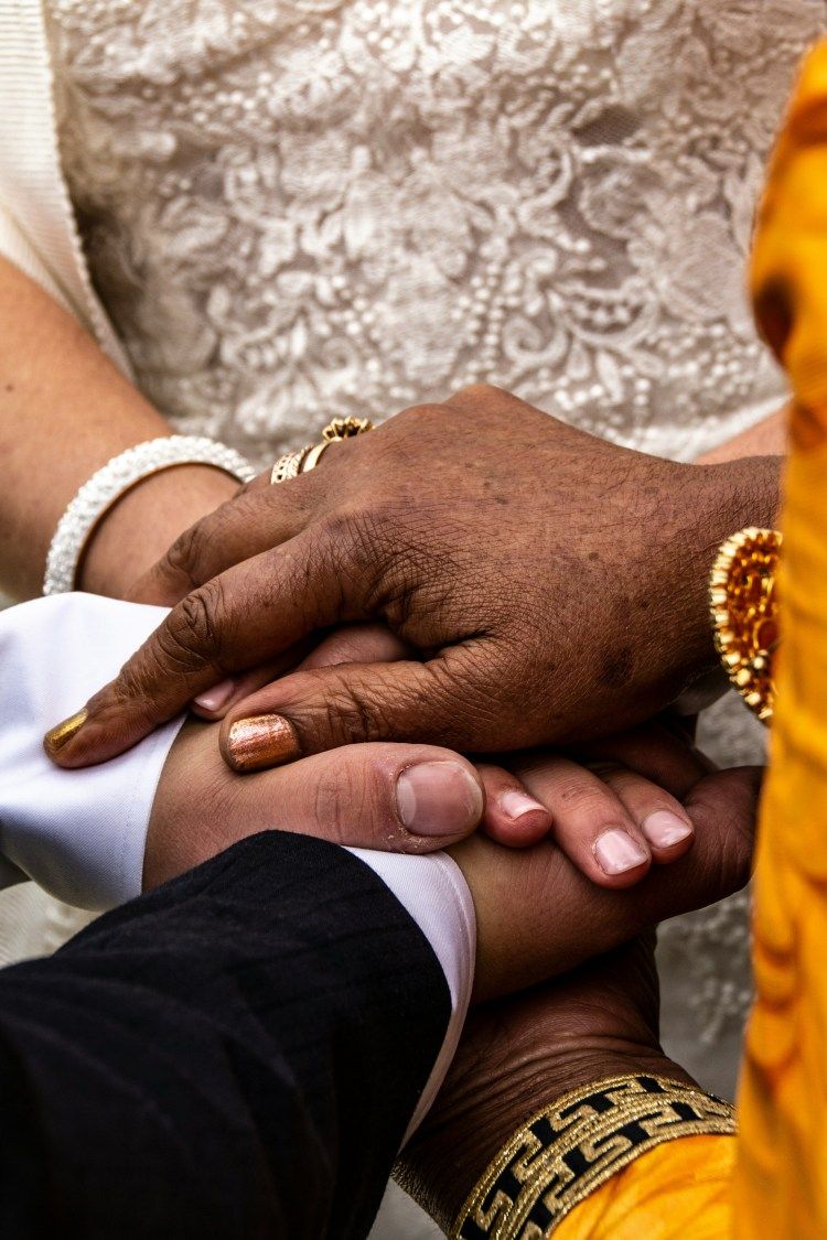 Several hands stacked together in a close-up, suggesting a group unity or celebration gesture.