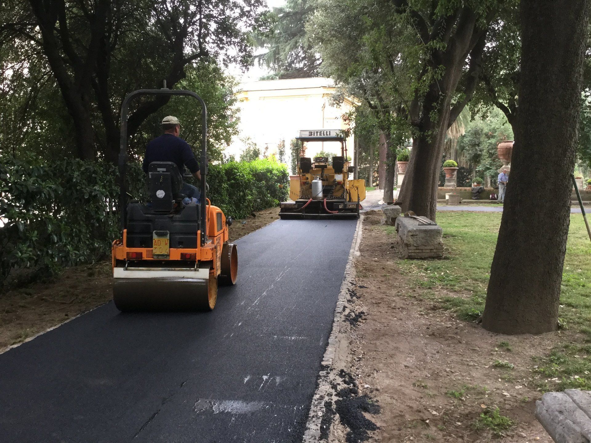 Rifacimento del manto stradale con rullo compressore e macchina asfaltatrice su un sentiero