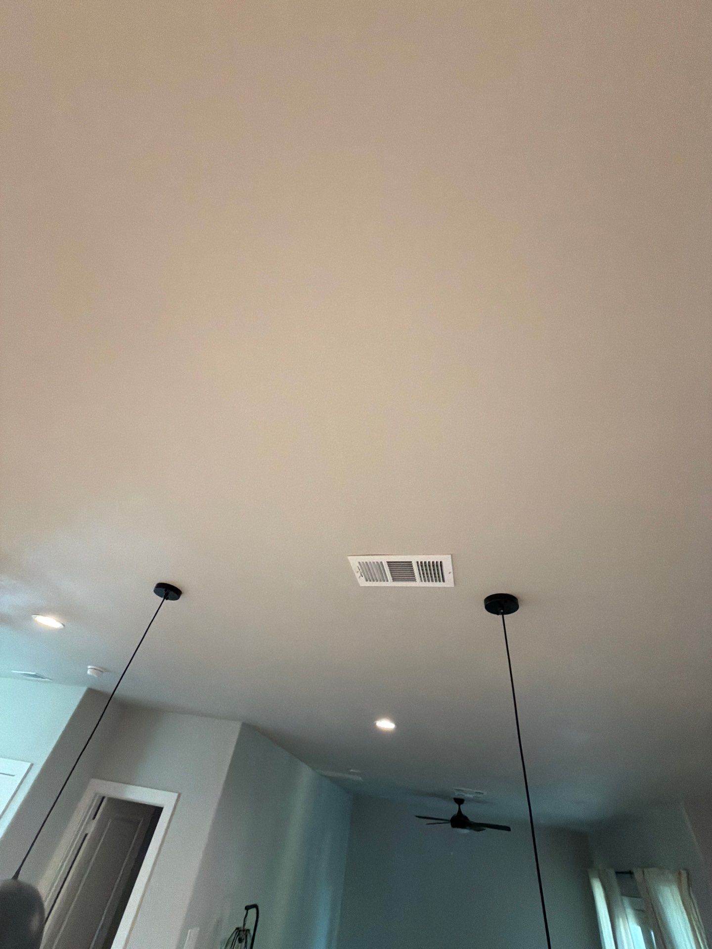 Ceiling in a modern room with recessed lights, ceiling fans, and hanging pendant lights