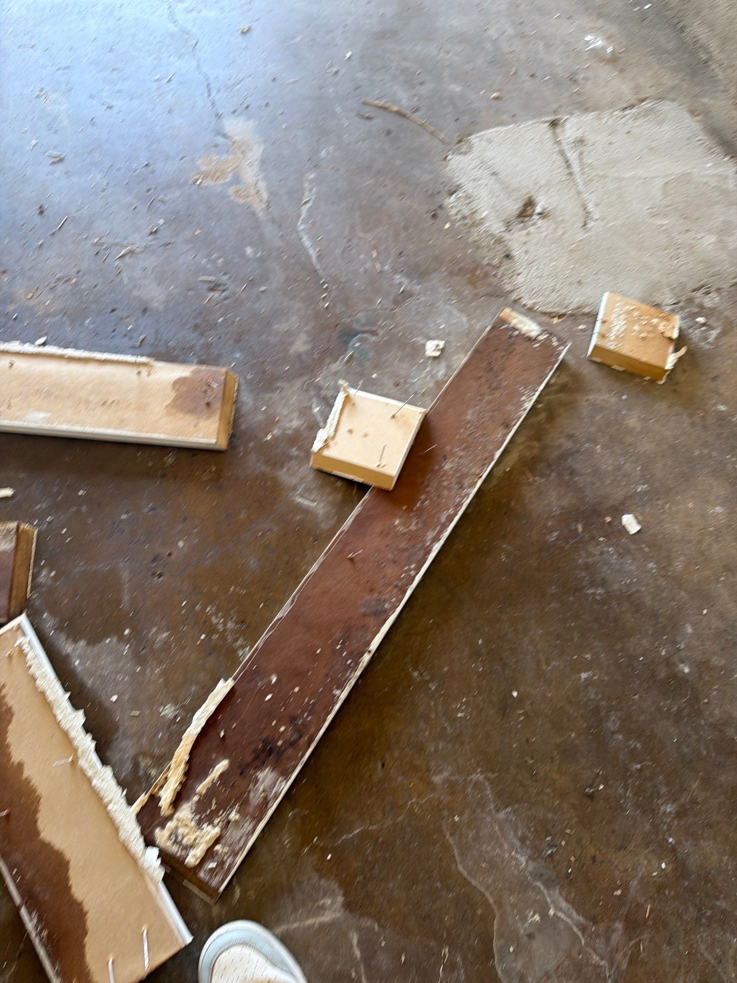 Broken wooden boards and scraps scattered on a concrete floor