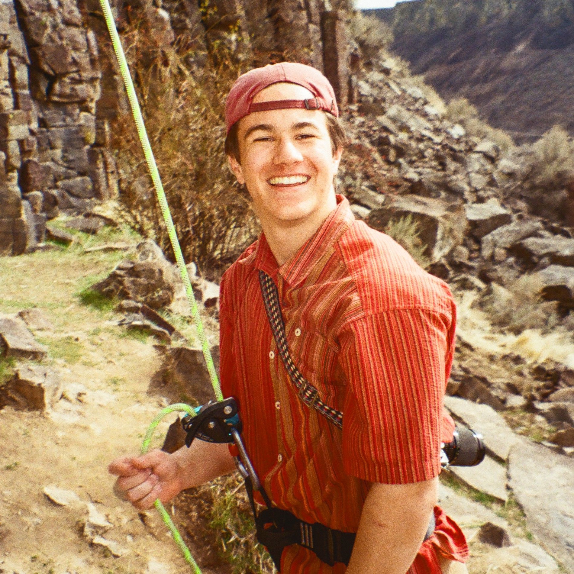 Staff member wearing a striped cap beside rocks