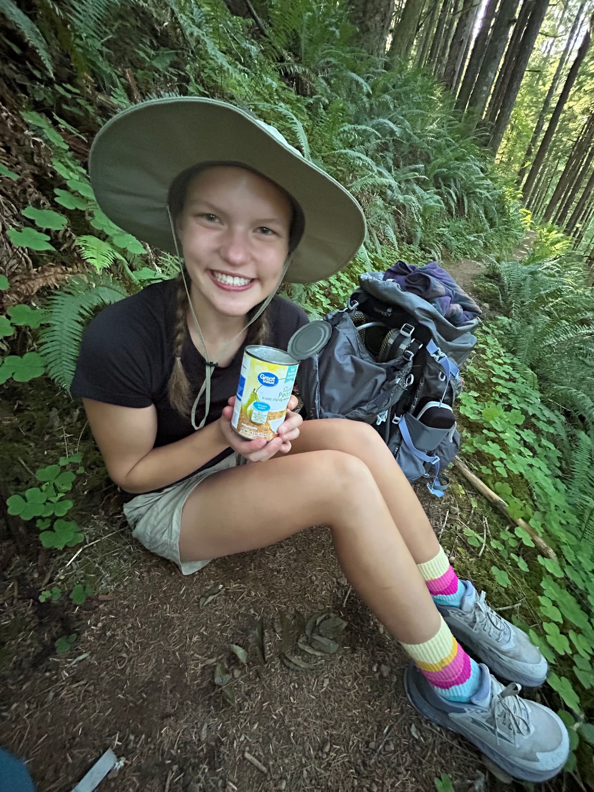Staff member wearing a wide-brimmed hat in a forest