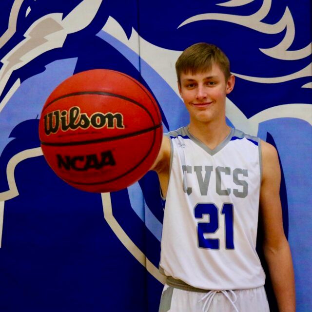 Staff member posing with a basketball