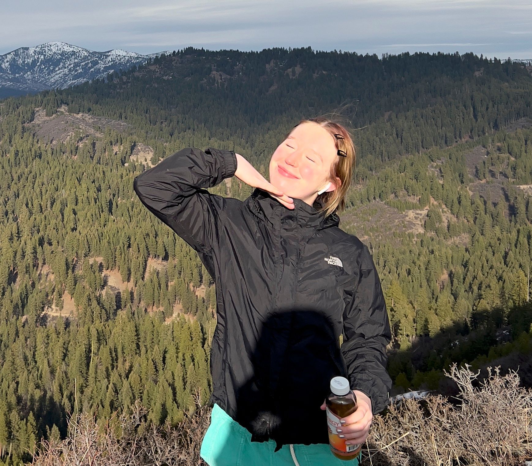 Staff member smiling on a forested hillside