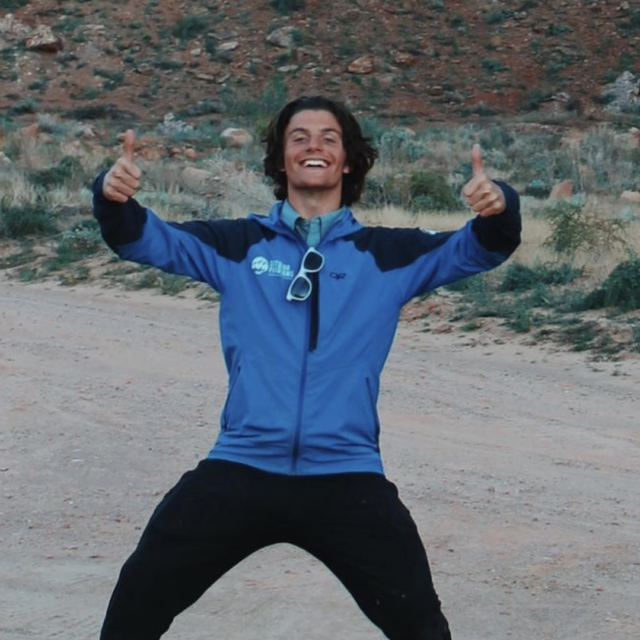 Staff member holding up both thumbs outdoors