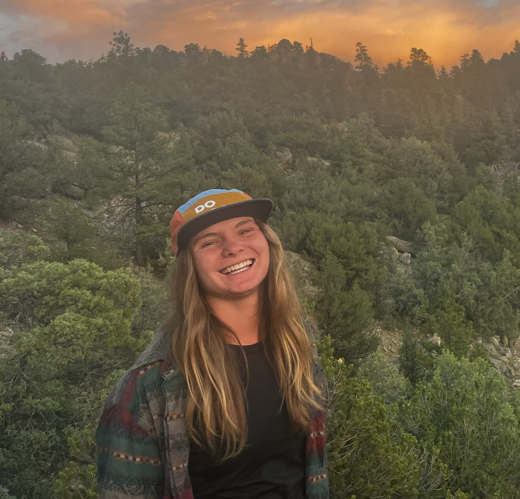 Staff member wearing a helmet with hills in the background