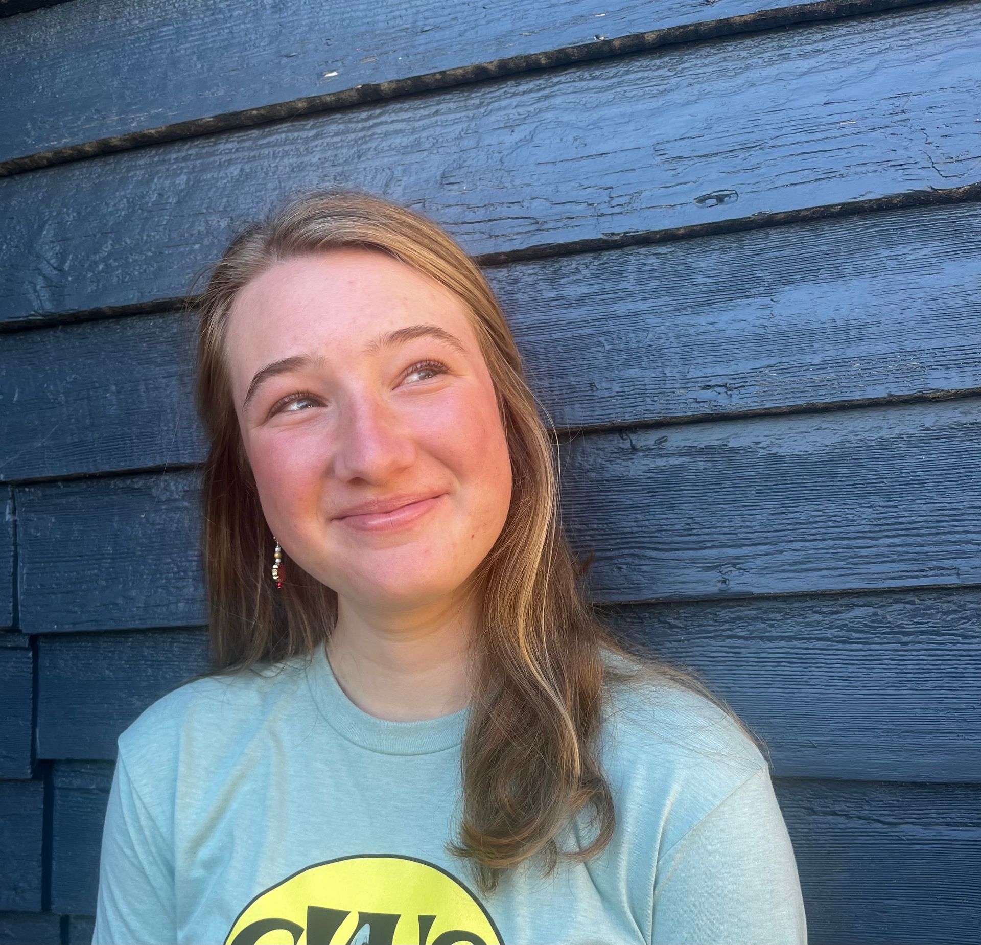 Staff member smiling beside a blue wall
