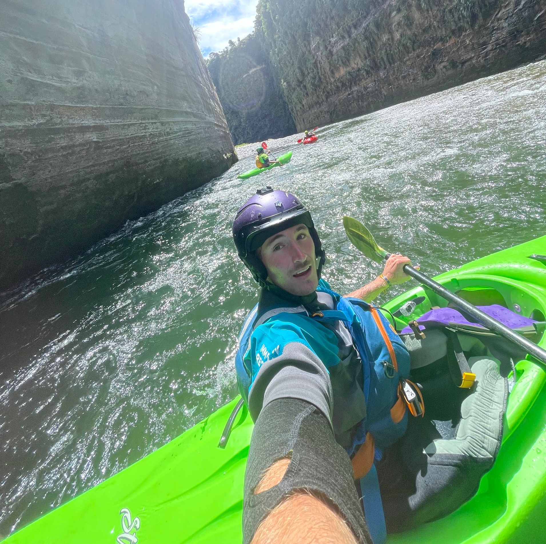 Helmeted kayaker on sunlit water