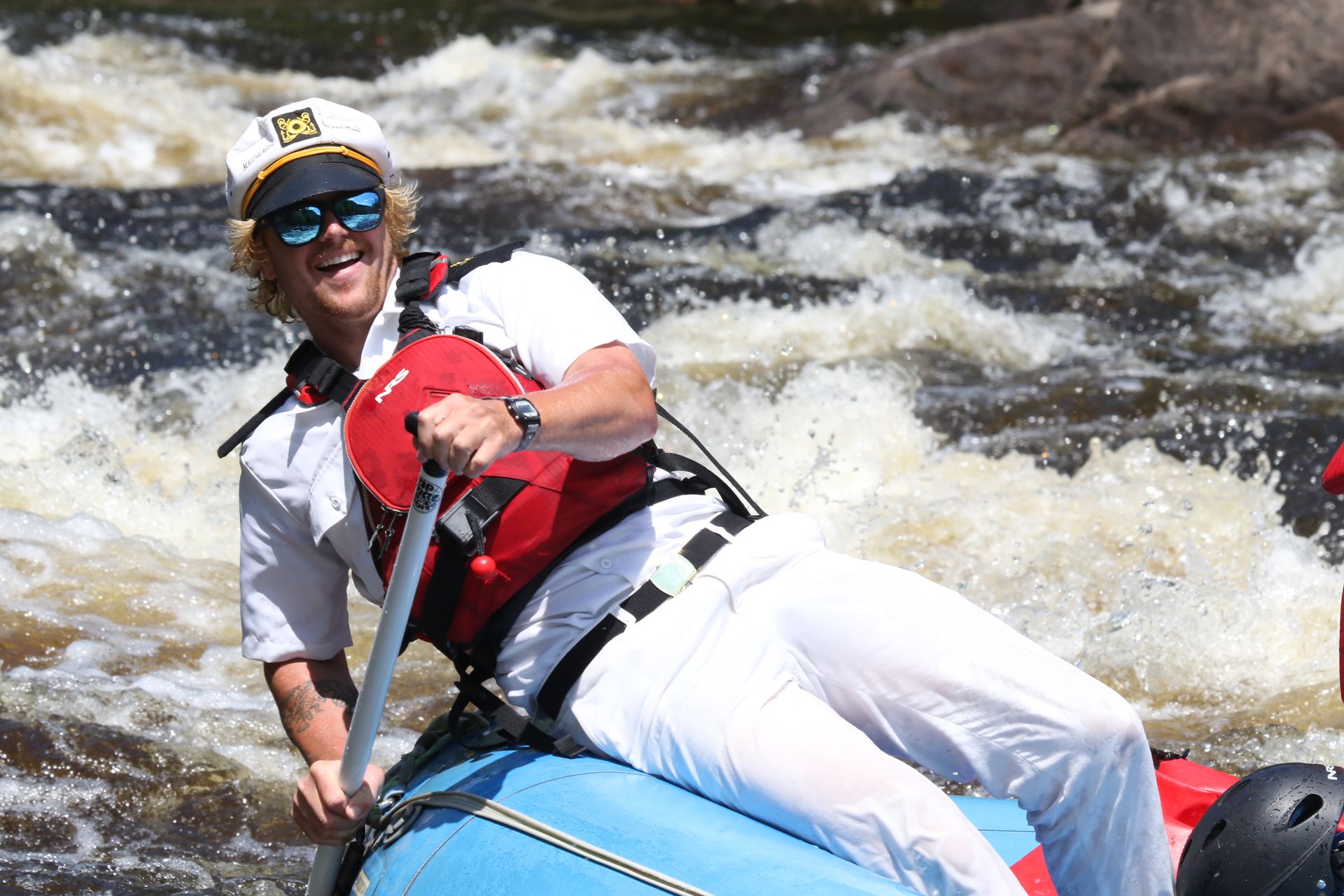Helmeted paddler beside whitewater rapids