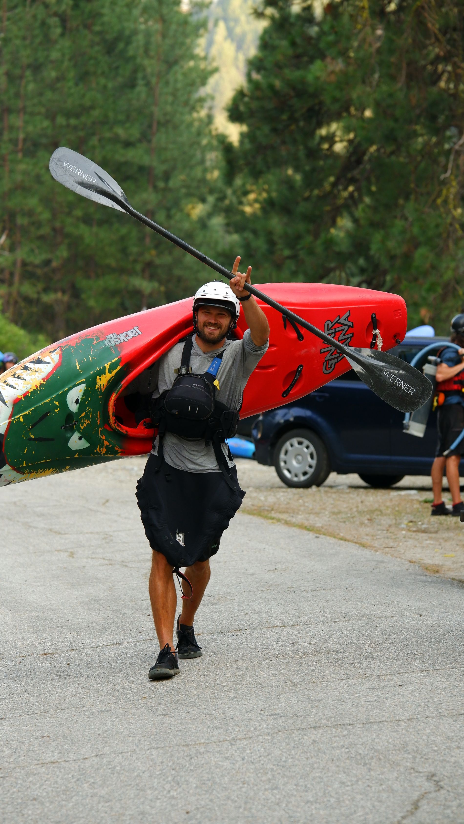 Kayak paddle beside a tree-lined river