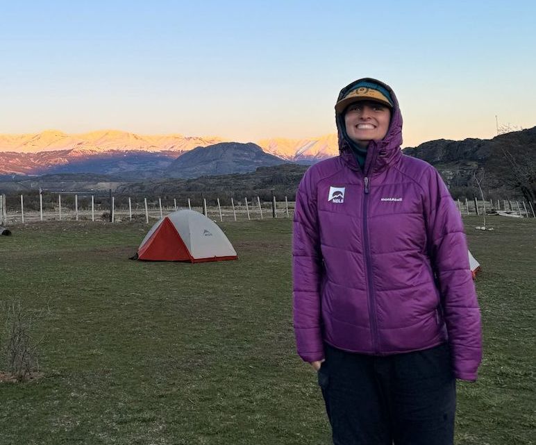 Staff member wearing a purple jacket at a campsite