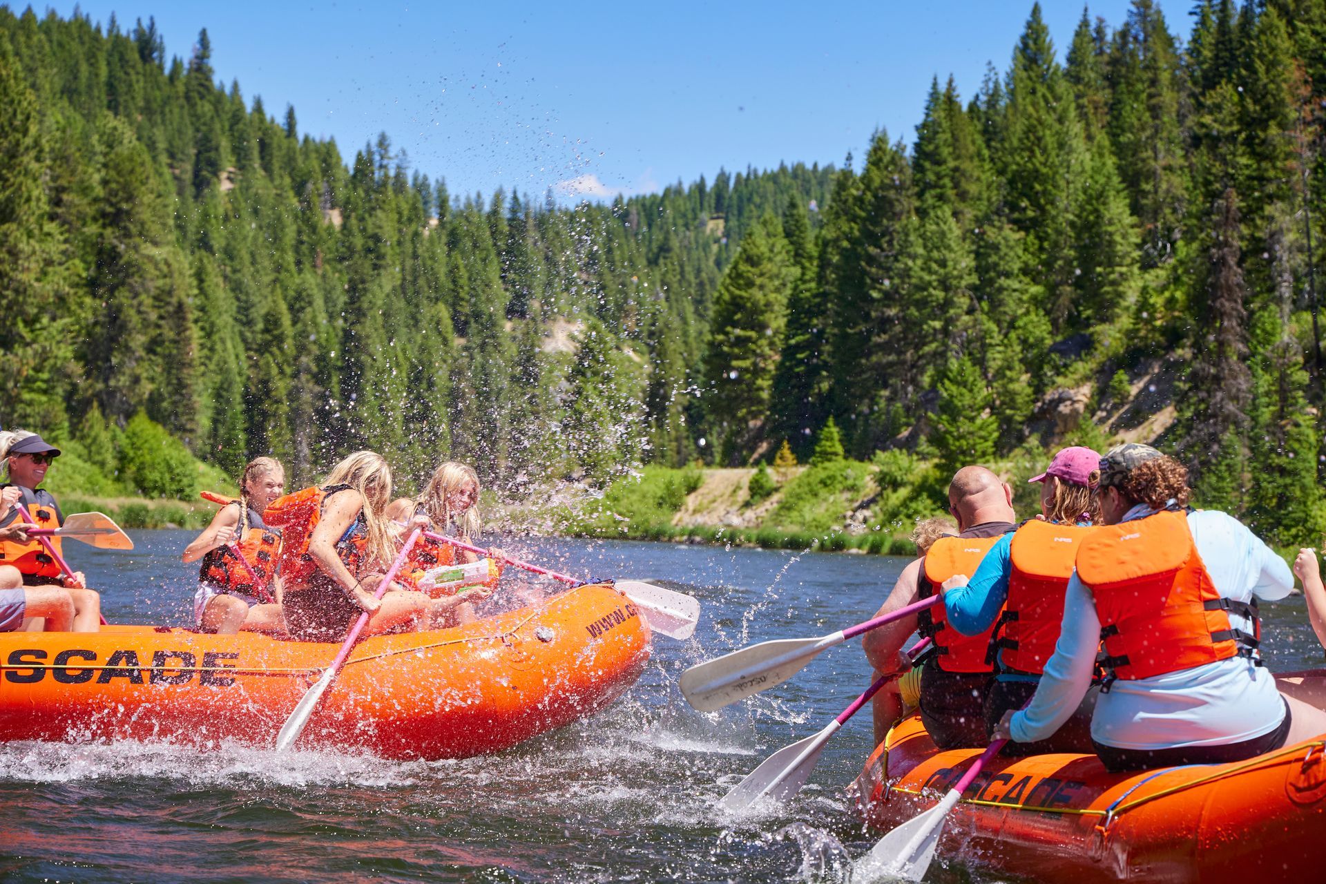 Family splashing each other on a whitewater rafting trip.