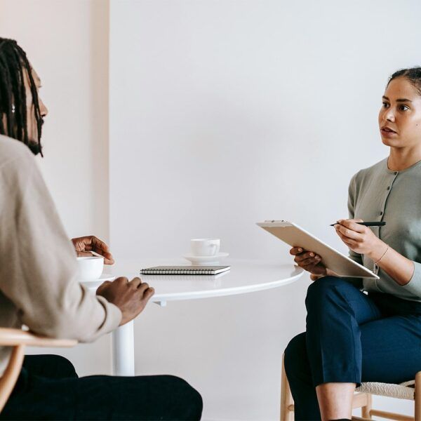 A man and a woman are sitting at a table having a conversation.