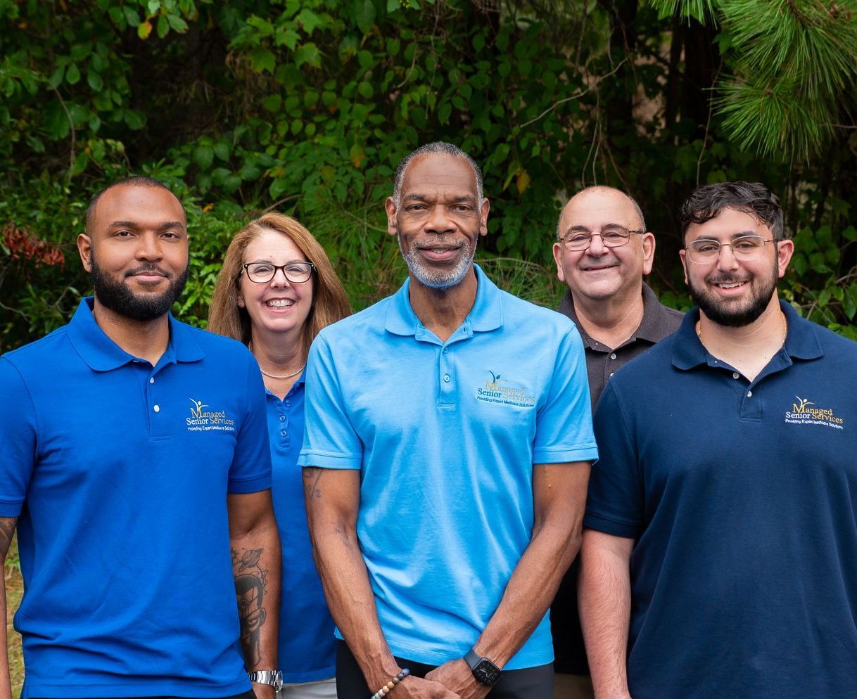 A group of people in blue shirts are posing for a picture.