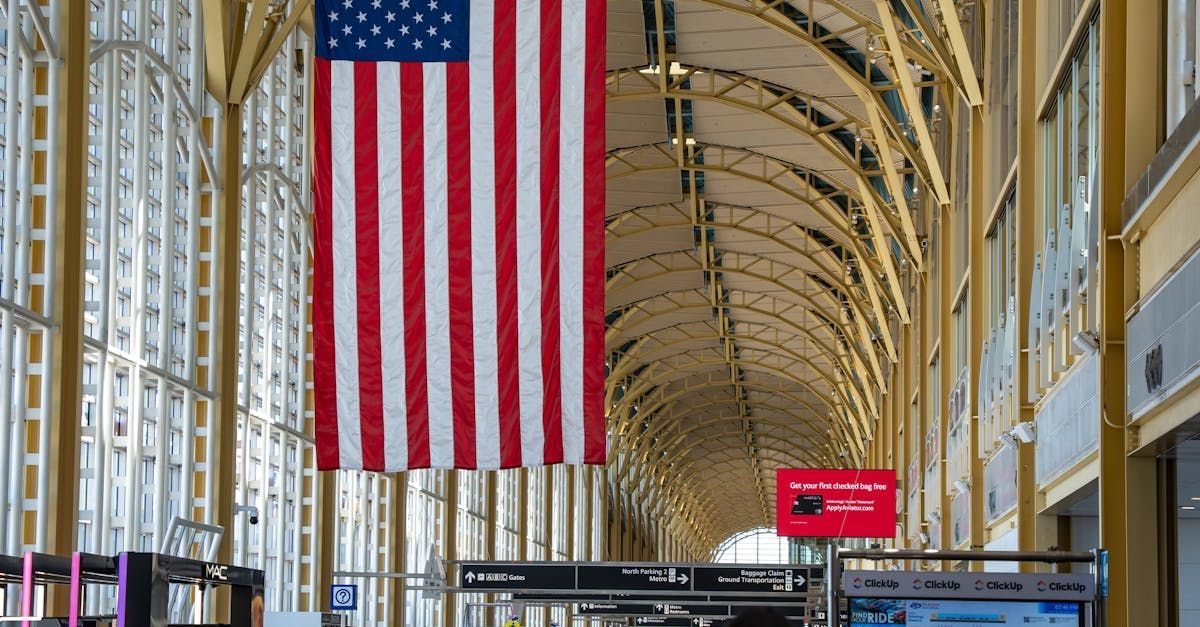 A large american flag is hanging from the ceiling of a building.