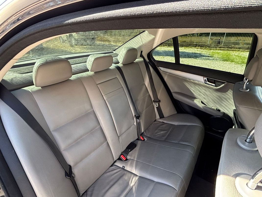 Interni di lusso neri per SUV con sedili singoli in pelle e luci d'ambiente sul soffitto.