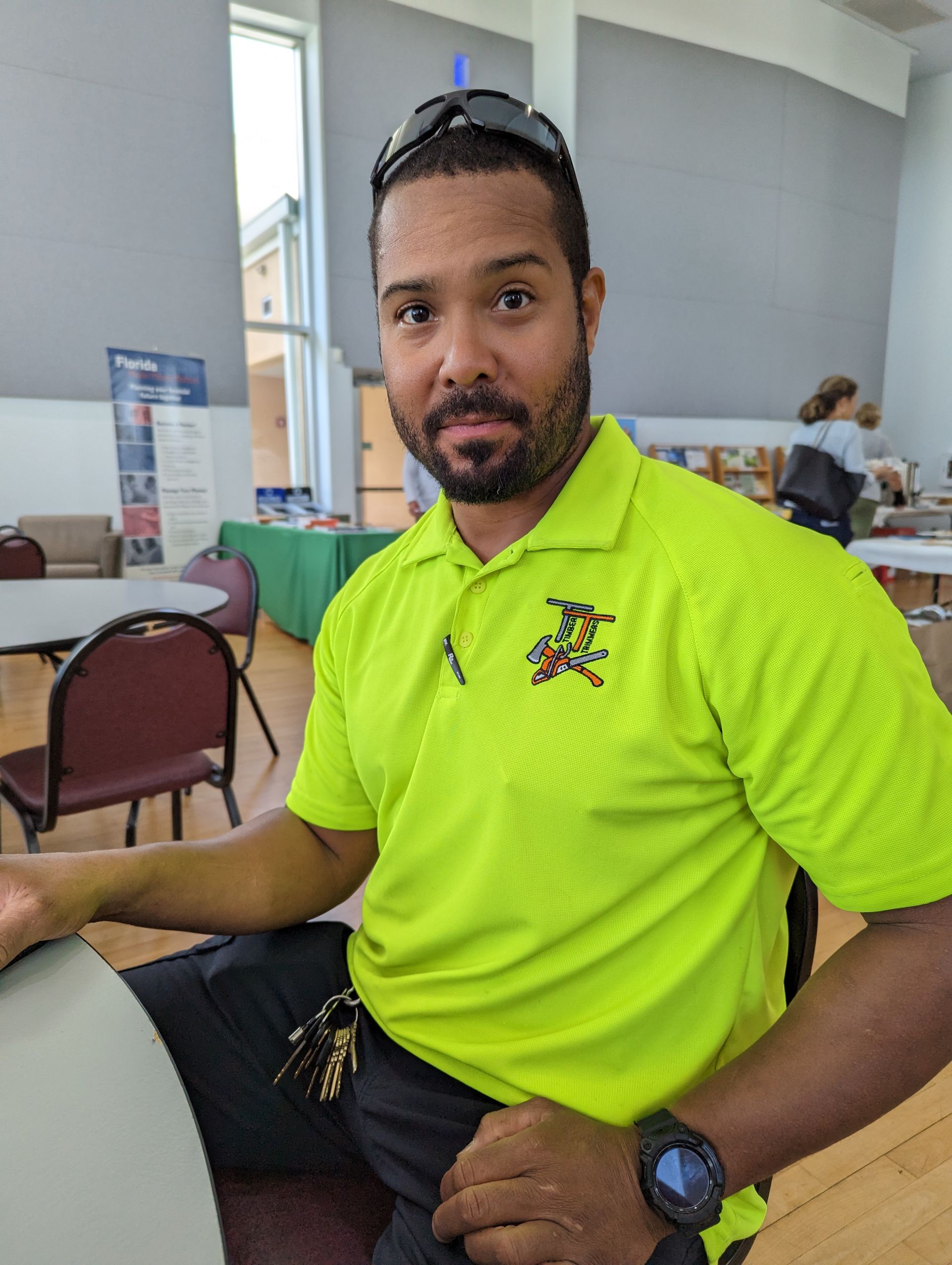 A man wearing a neon yellow shirt is sitting at a table