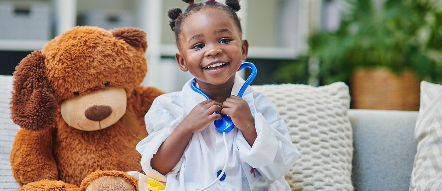 Girl playing doctor with a teddy bear