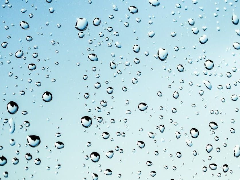 Water droplets on a light blue glass surface