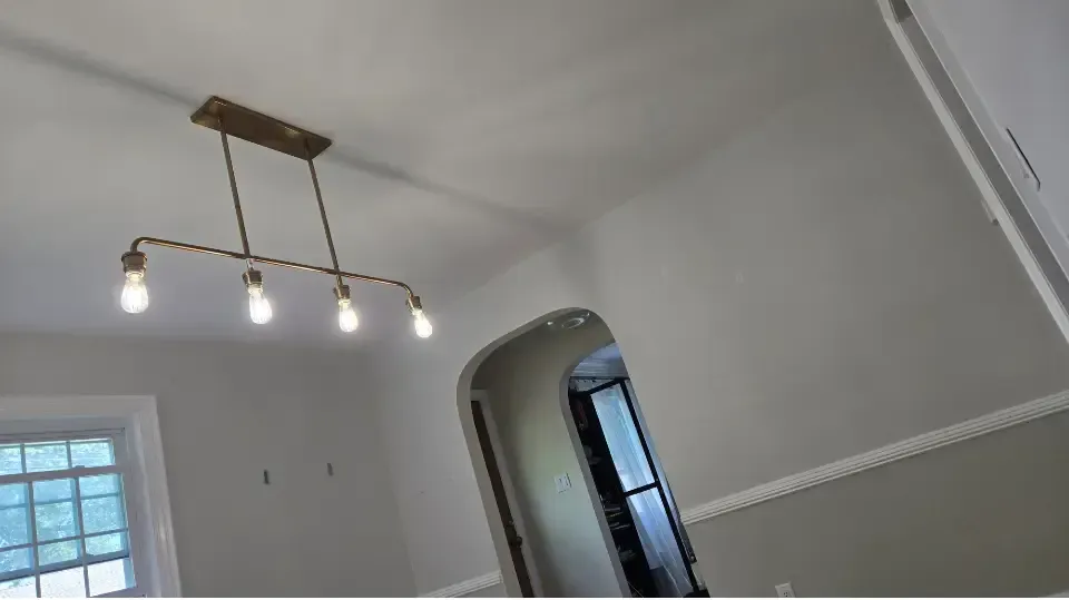 Tilted view of a bright room with a brass ceiling light and arched doorway