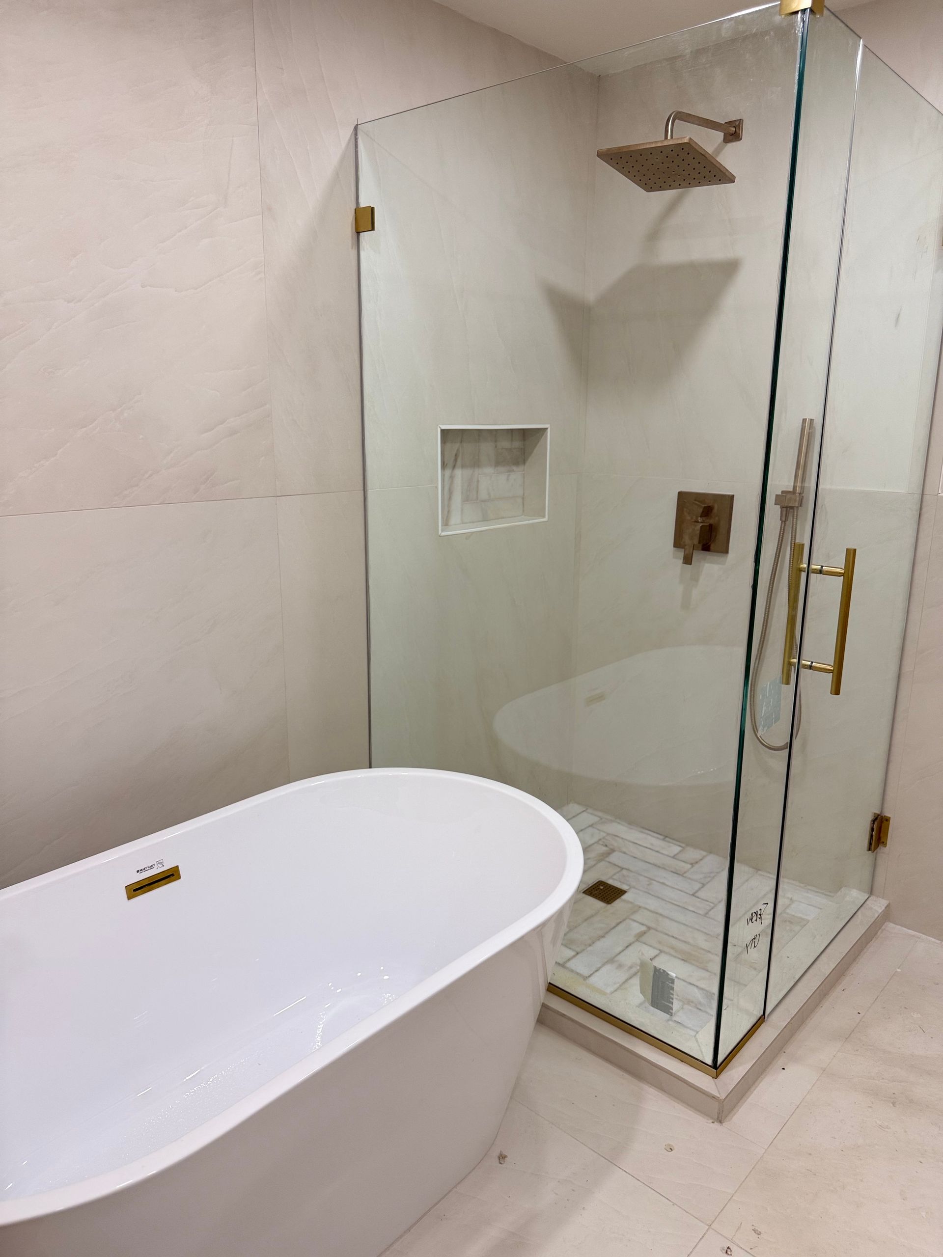 Modern bathroom with a freestanding white tub and glass-enclosed walk-in shower.