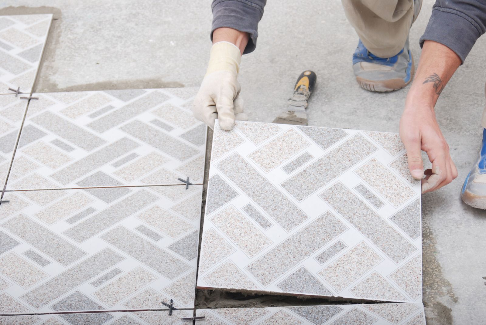 Wet concrete pouring from a truck chute onto a construction site, forming a gravelly slab surface