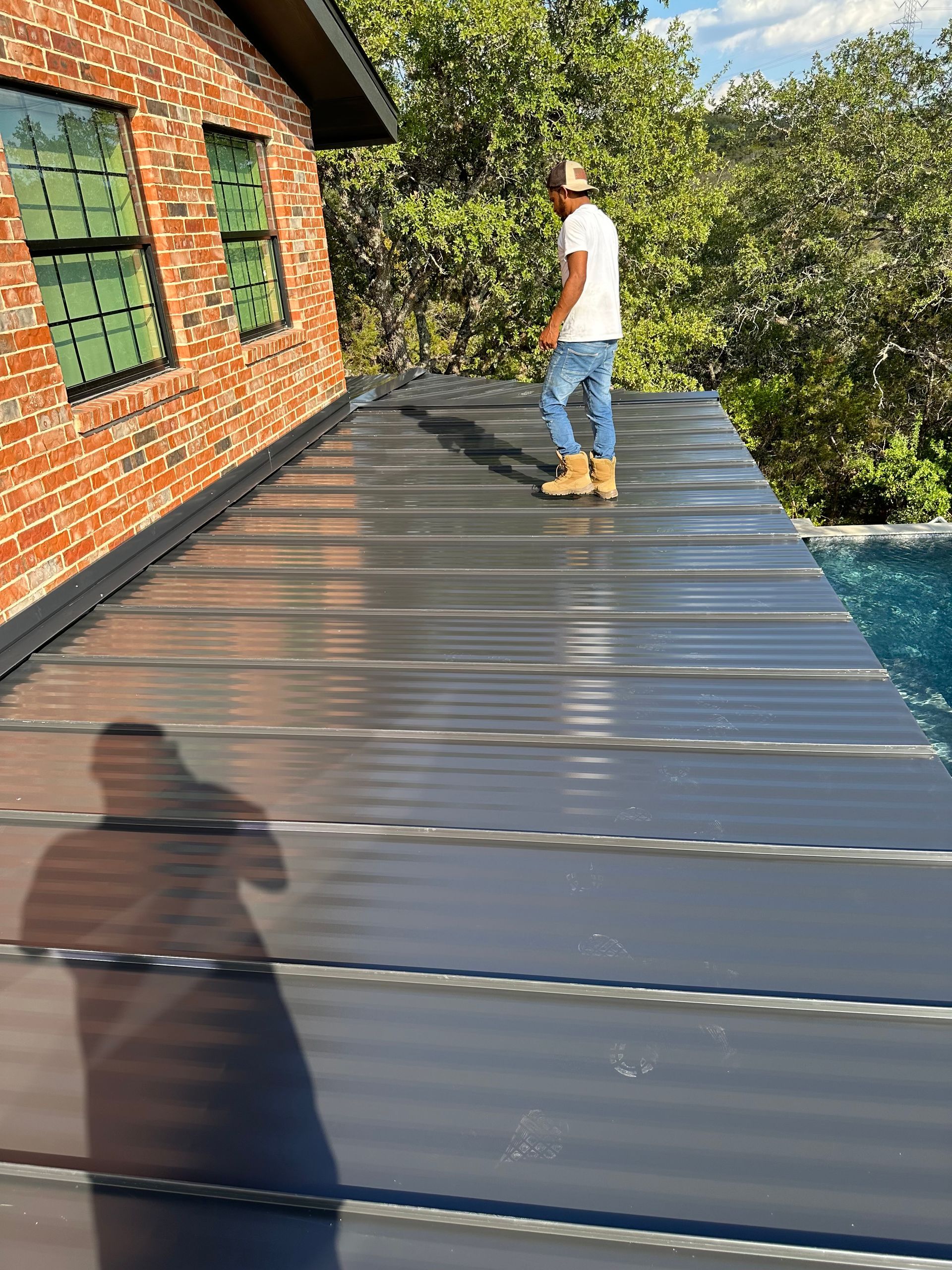 A man is standing on the roof of a brick building.