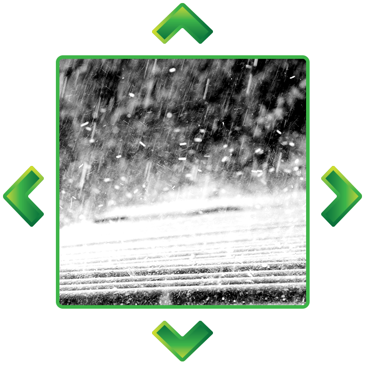 A black and white photo of rain falling on a road