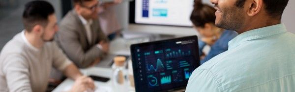 Entre em contato com a Visual Systems Equipe de profissionais de TI em ambiente corporativo, analisando gráficos e dados durante implementação de sistema.