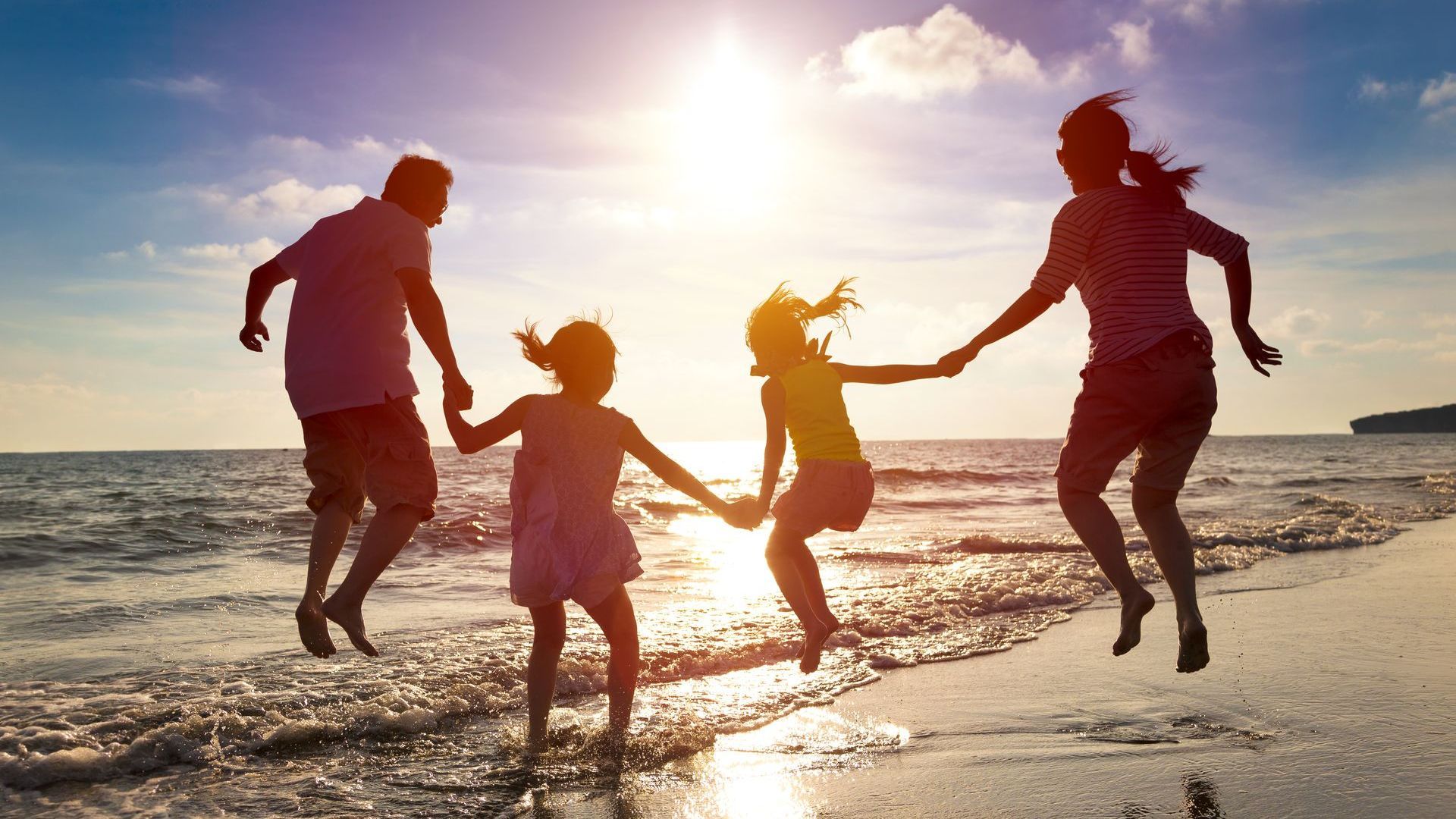 Family jumping together on the beach