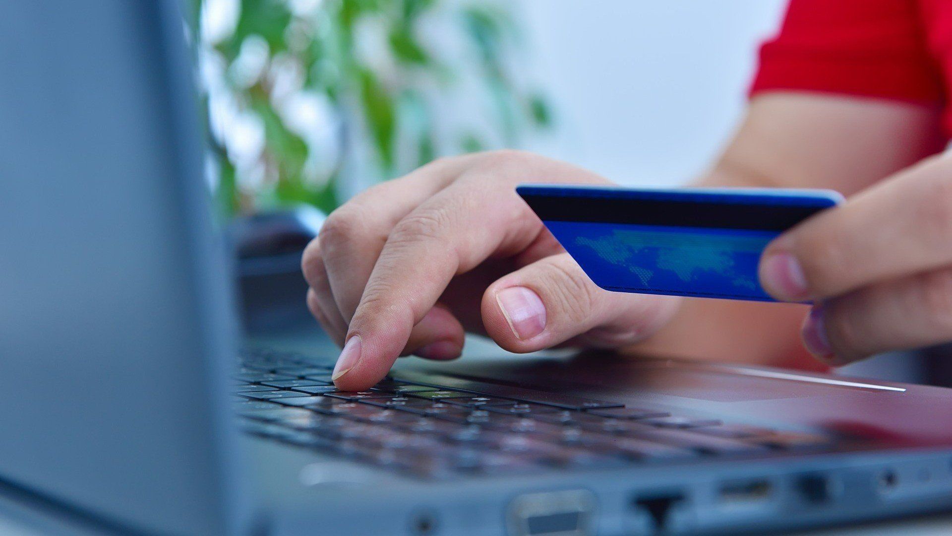 Persona con carta di credito in mano al computer