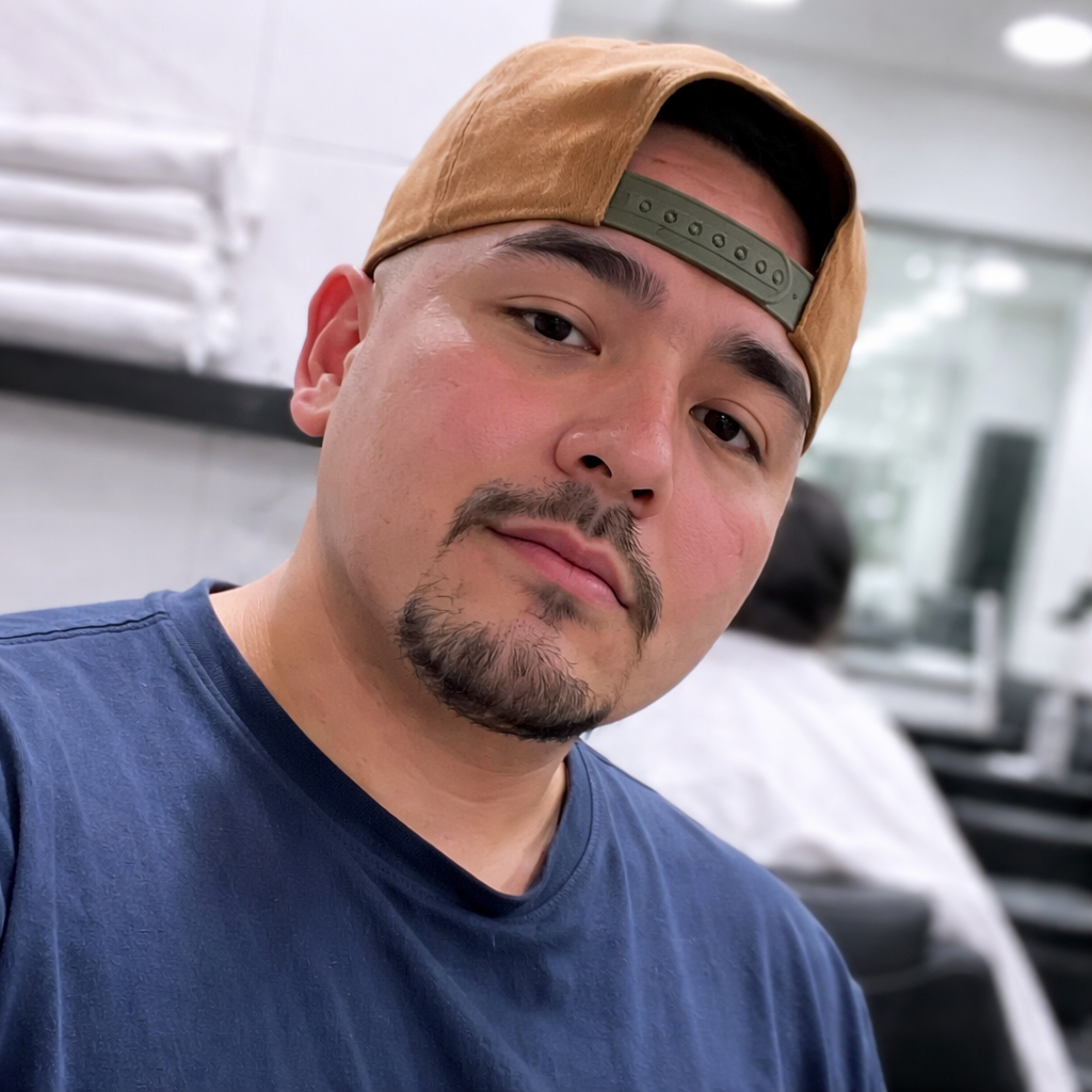 Barber Uzi, owner of The Cave Hype Barbershop in Phoenix, AZ