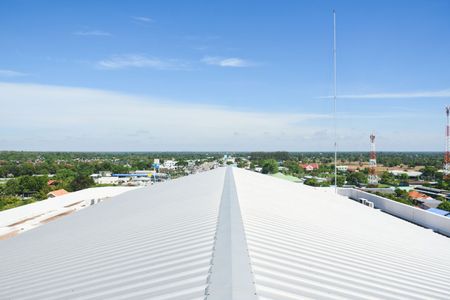View from a white corrugated roof over a town under a clear blue sky
