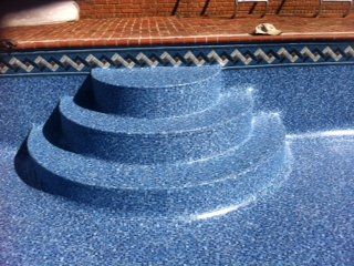 Blue tiled pool steps. Empty pool with blue mosaic-like tiling. 