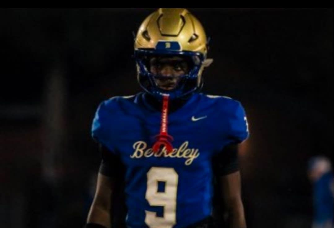 Football player in blue Berkeley jersey with gold helmet, standing in a dimly lit tunnel