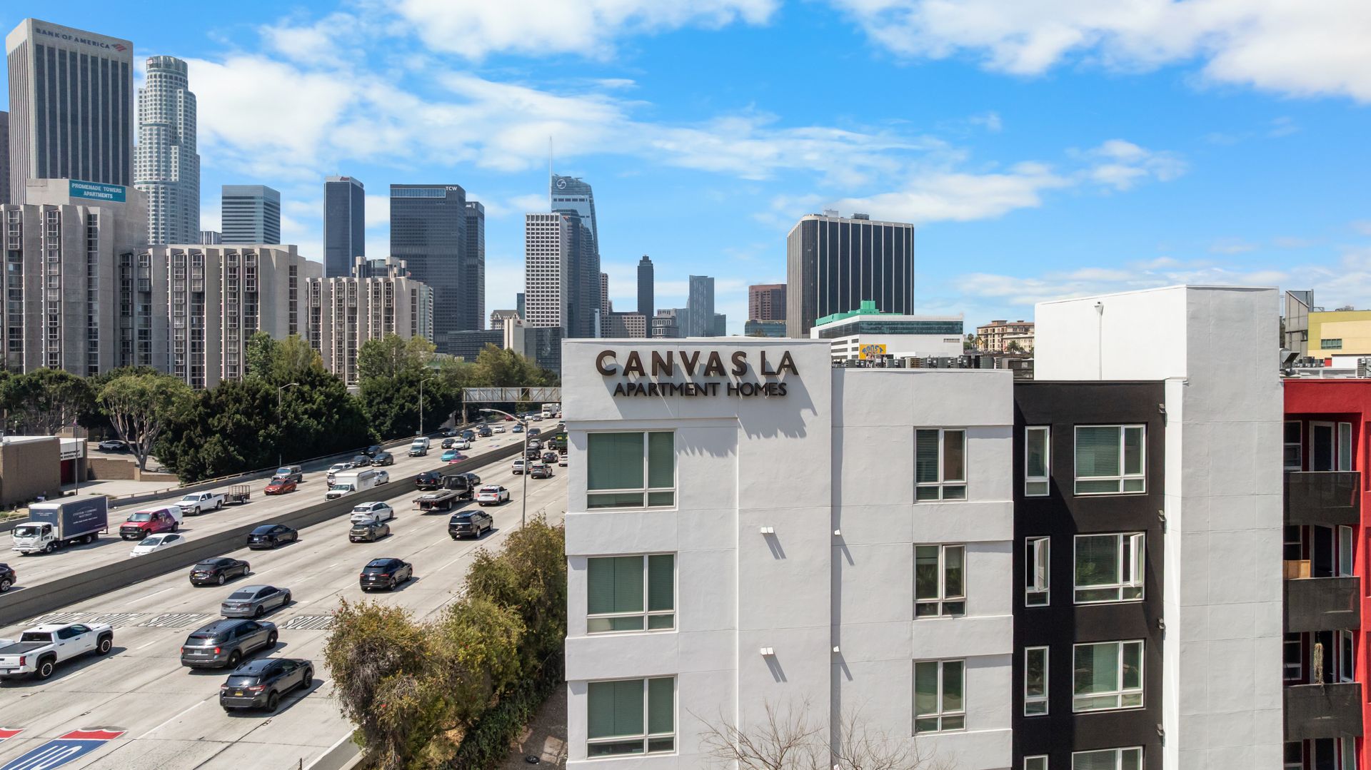 The corner of a building with a name Canvas LA with skyscrapers in the background