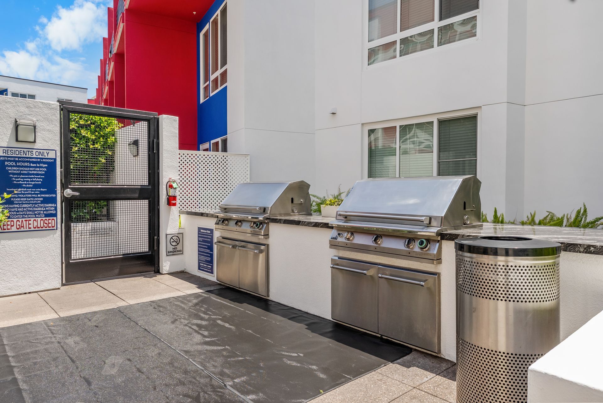 two bbq grills and a trash can