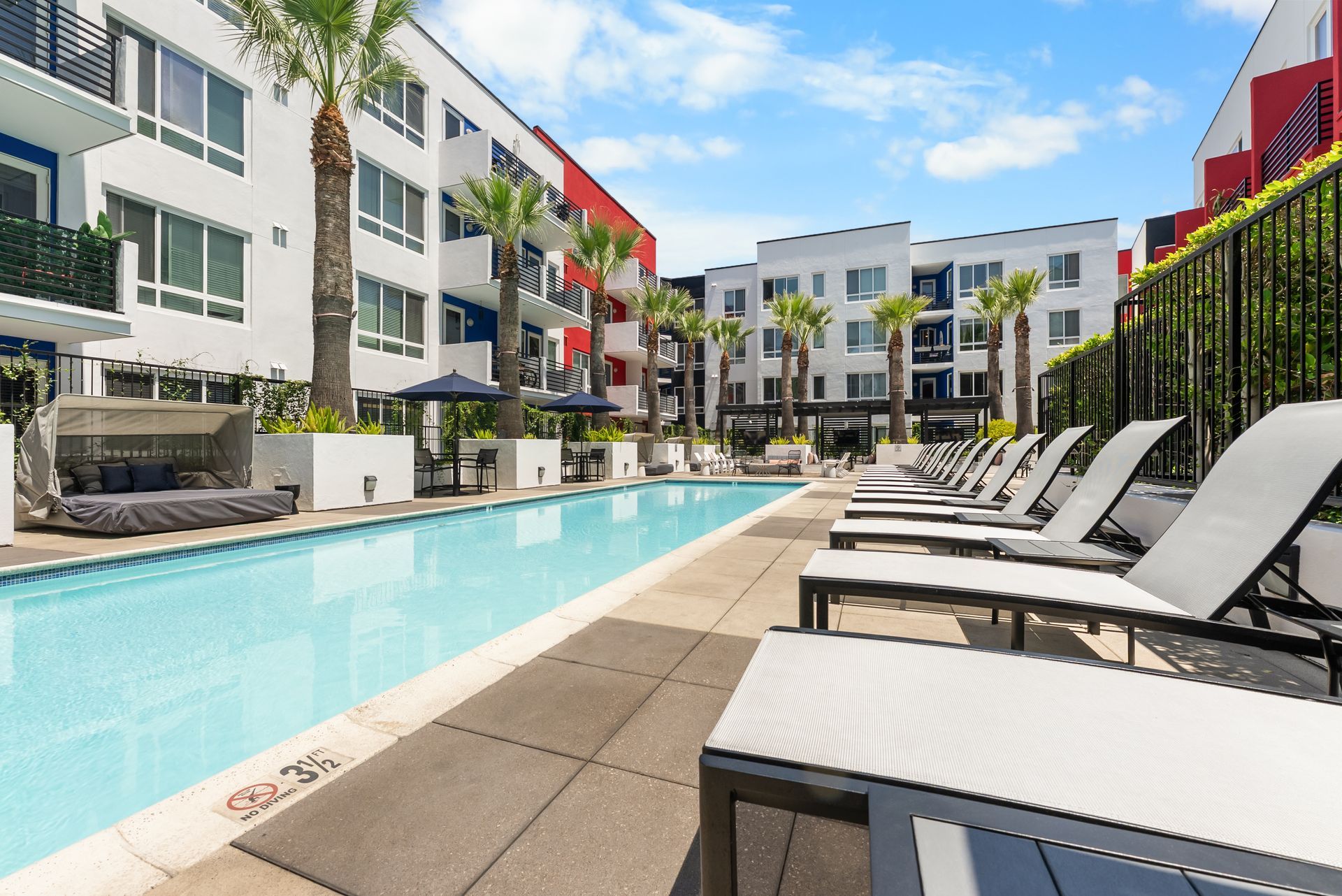 A pool with lounge chairs on one side