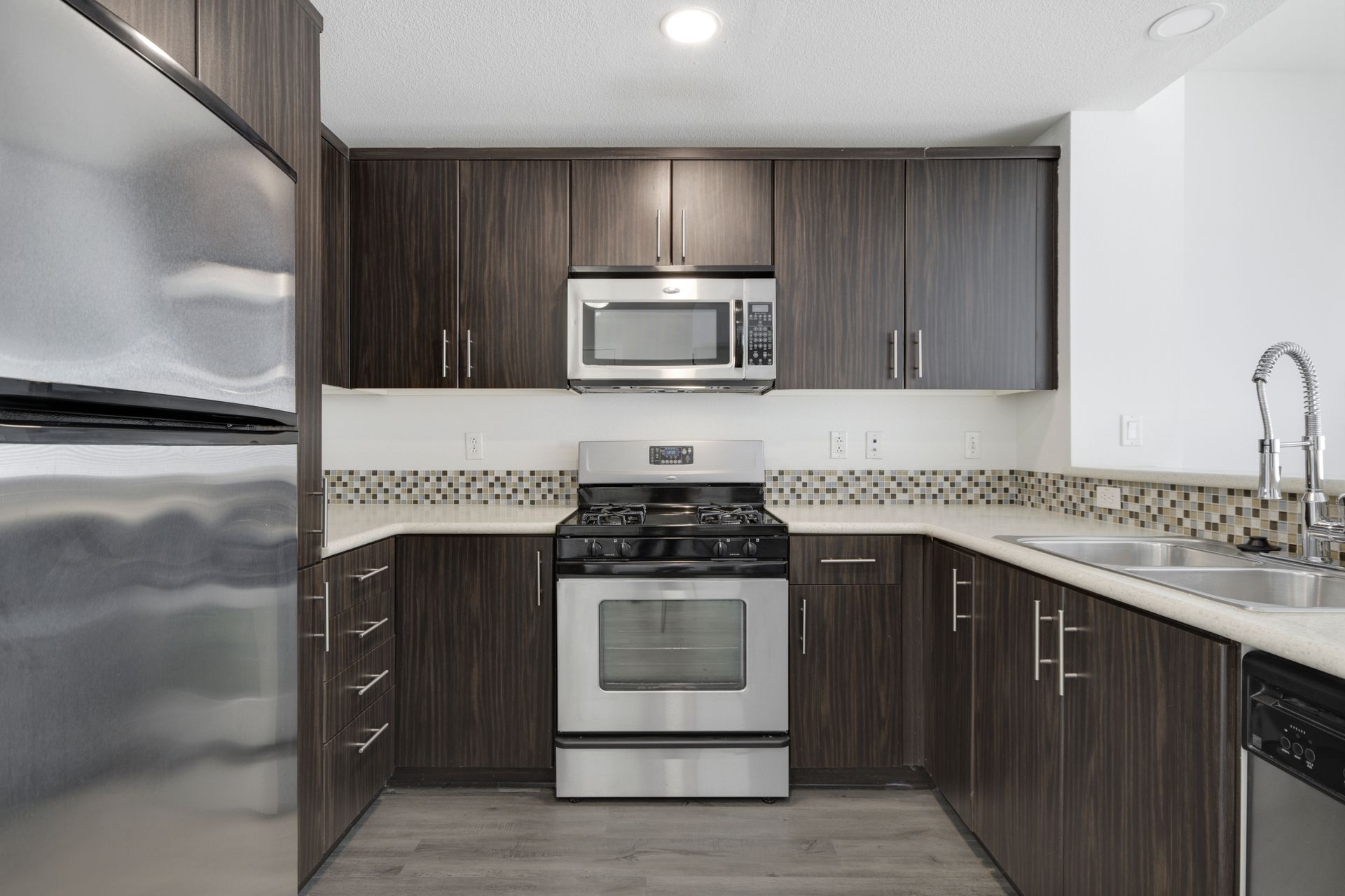 an empty kitchen with a stove and microwave