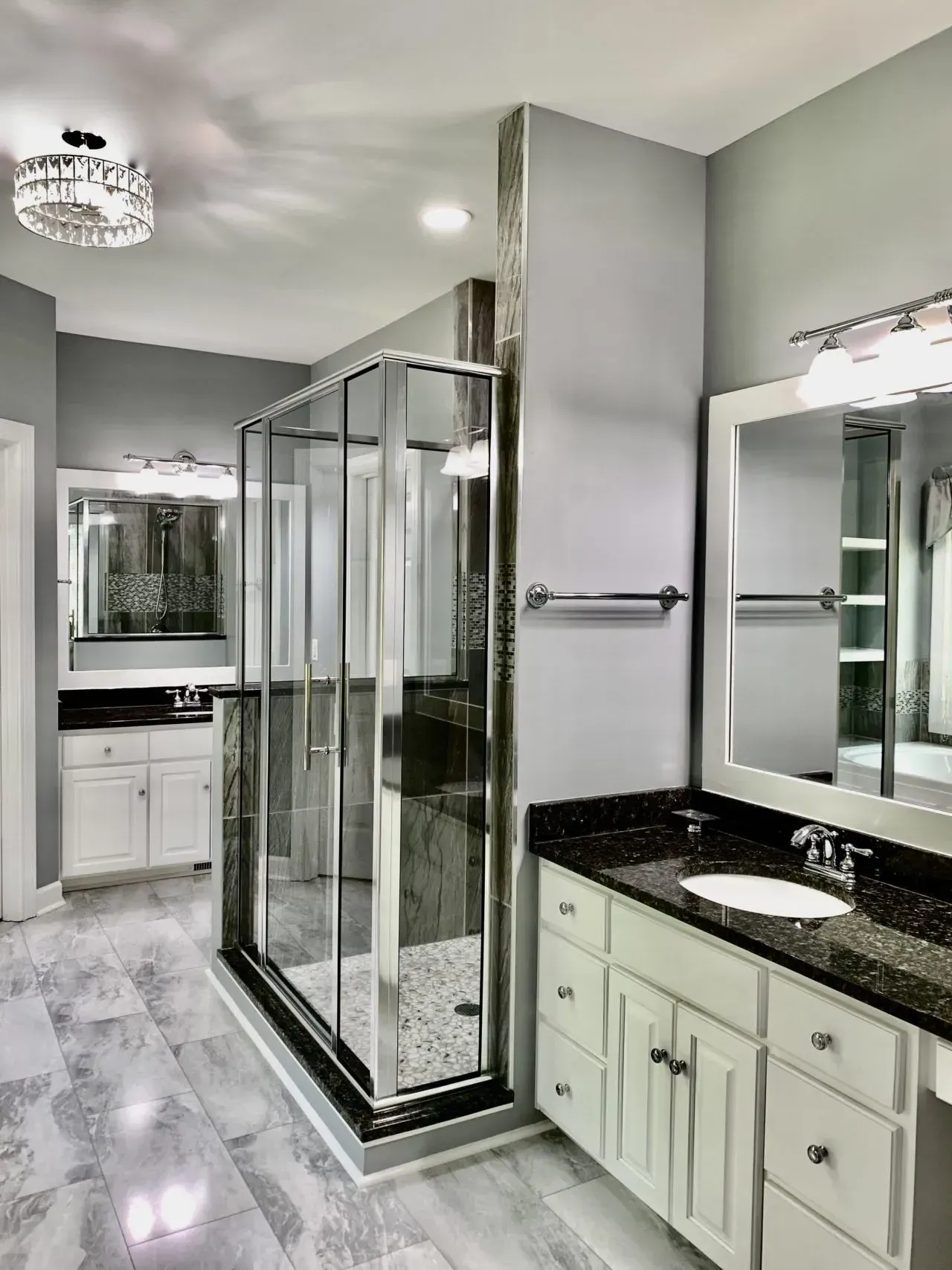 A bathroom with a walk in shower , sink and mirror.
