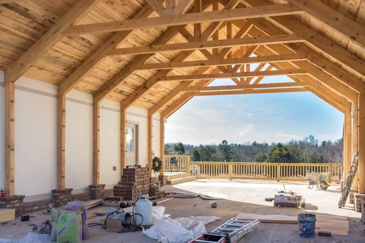 A large wooden structure is being built on a sunny day.
