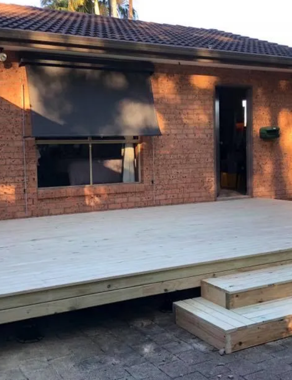 Wooden Deck With Steps Next to a Brick House With a Window and Awning — Alcando Renovations and Maintenance In Old Bar, NSW