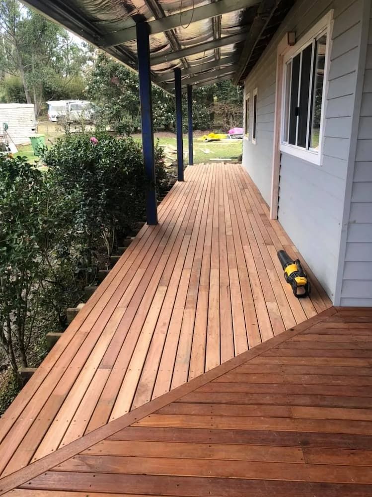 Wooden Deck With Dark Brown Boards and Light Gray Building Wall — Alcando Renovations and Maintenance in Bobin, NSW